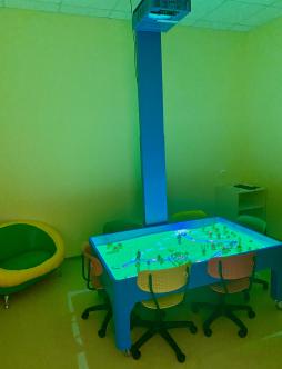 Интерактивная комната в детском саду 

Интерактивная песочница от компании «Инновации детям» – современное игровое оборудование, включающее в себя обычный песок и интерактивные технологии. Проецируемое изображение на песке взаимодействует с движениями рук, позволяя строить различные ландшафты, окрашенные в разные цвета. Реальная река, проложенная на песке, настоящие горы, извергающийся вулкан, моря с плавающими рыбами, города и т. д. Интерактивная песочница подходит для любых занятий с детьми в детском саду, материал подается в новой, занимательной форме, ребенок создает свой, неповторимый волшебный мир.